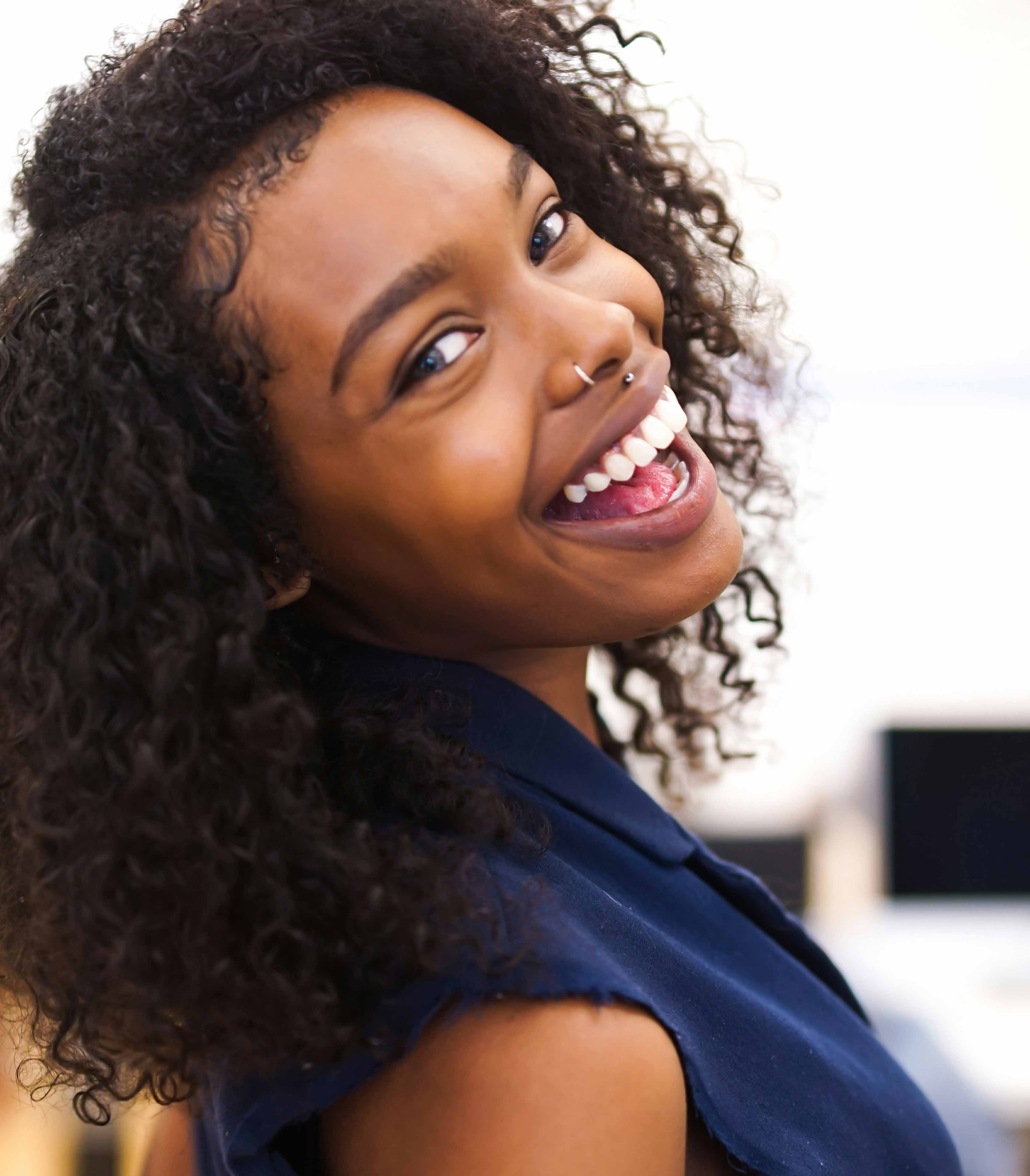 Person smiling into the camera which is angled from behind